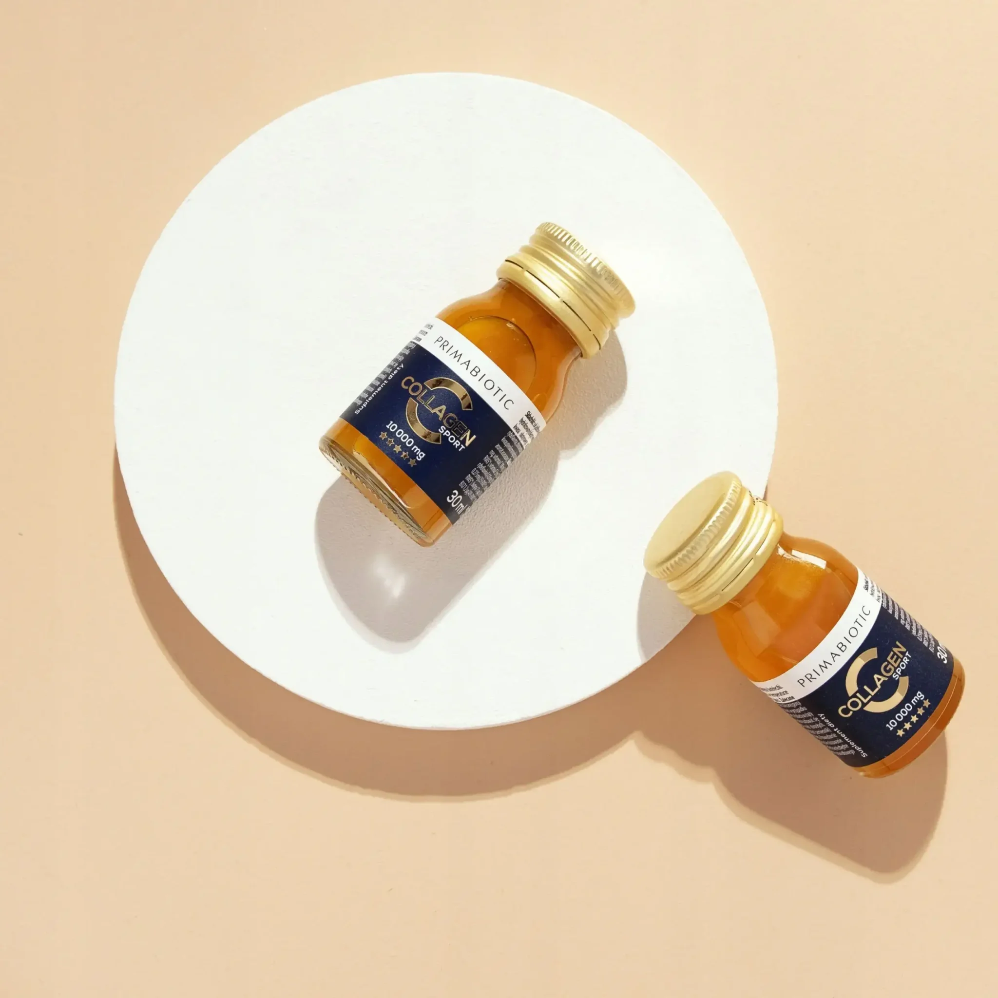 Dwie buteleczki kolagenu Sport Primabiotic 10 000 mg ułożone na jasnym tle w minimalistycznym stylu.