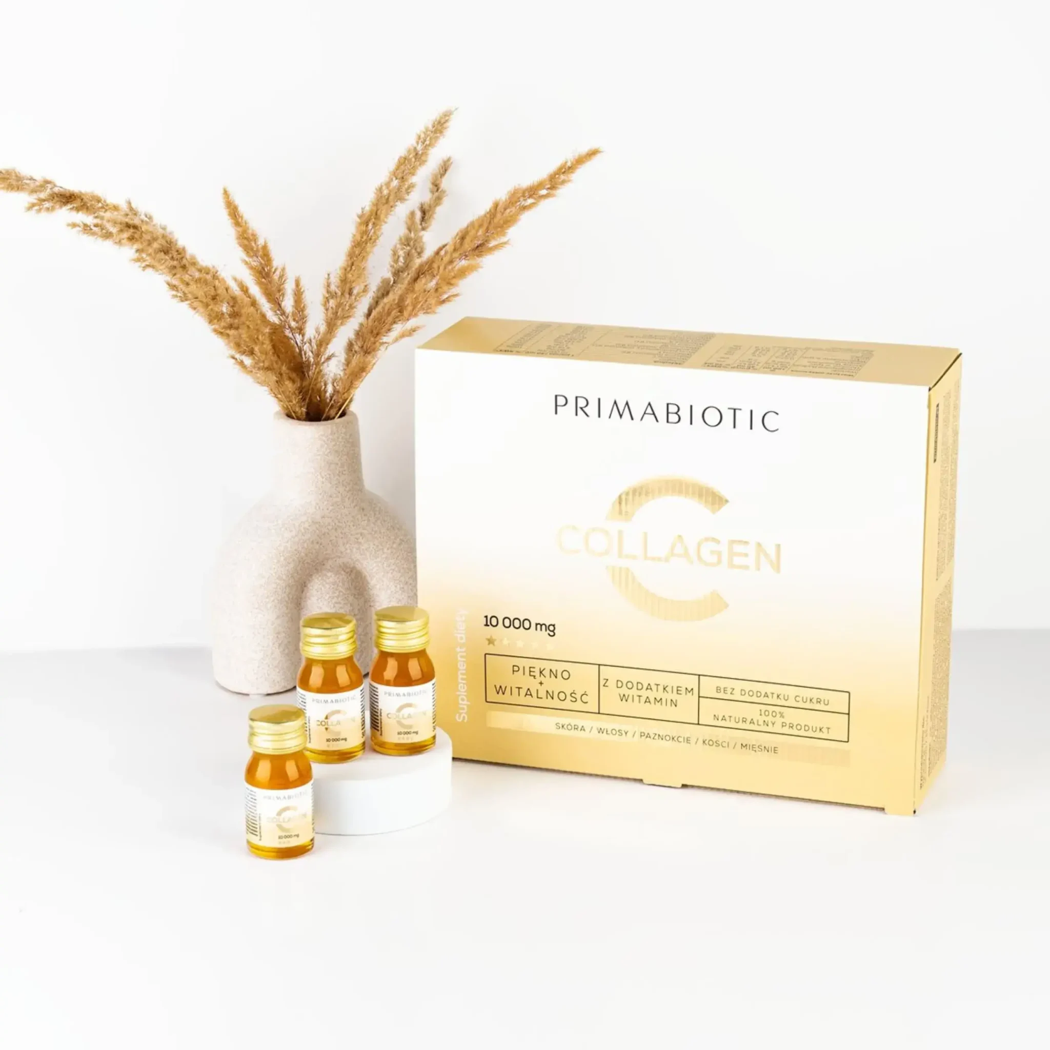 Zestaw kolagenu Primabiotic z buteleczkami i ozdobną aranżacją na jasnym tle.